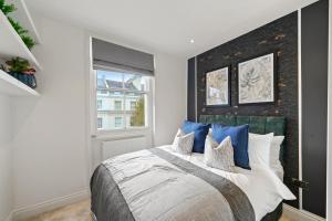 een slaapkamer met een groot bed met blauwe kussens bij Grand Flat in Little Venice - Sleeps 8 in Londen
