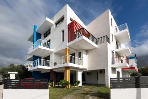 a white building with red and blue balconies at Pagani Blue - Luxury Maisonette B3 in Kalamata