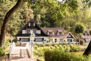 a black and white house with a staircase leading to it at Forsthaus Seebergen in Lütjensee