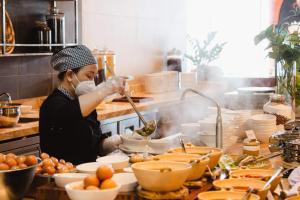 a woman is preparing food in a kitchen at PANORAMA OCEANFRONT SUITE in Nha Trang