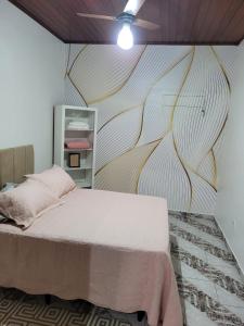 um quarto com uma cama e um mural de parede em APTO DUPLEX 3 Dorm. em APARECIDA 600 m da basilica em Aparecida