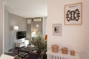 - un salon avec un canapé et une télévision dans l'établissement L1 Suite Auguste Valensin 10 min à pied Mer Clim&WIFI, à Nice