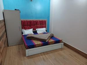 a bed with a red headboard in a room at Paradise Home stay in Rāni Pokhri