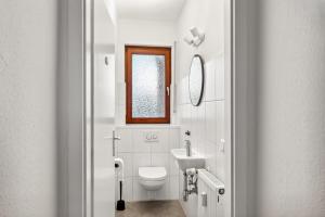 Baño blanco con aseo y lavamanos en Amalfi Apartment A03 - 3 Zi.+ bequeme Boxspringbetten + smart TV, en Eltville am Rhein