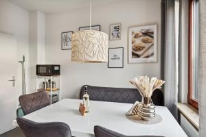 a dining room with a white table and chairs at Amalfi Apartment A03 - 3 Zi.+ bequeme Boxspringbetten + smart TV in Eltville