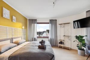 a bedroom with a teddy bear sitting on the bed at Amalfi Apartment A03 - 3 Zi.+ bequeme Boxspringbetten + smart TV in Eltville