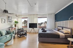 1 dormitorio con cama y pared azul en Amalfi Apartment A03 - 3 Zi.+ bequeme Boxspringbetten + smart TV, en Eltville am Rhein