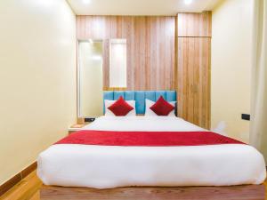 una camera da letto con un grande letto con cuscini rossi di Hotel Anju Shree Inn a Jaipur