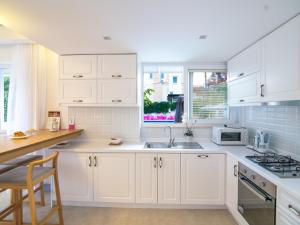 una cocina blanca con armarios blancos y fregadero en Kalkan Suites 202 en Kalkan