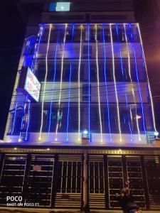 un bâtiment avec des lumières bleues sur son côté dans l'établissement PRATIMA GUEST HOUSE , Kolkata, à Kolkata