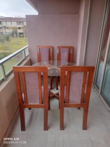 a dining room table and four chairs on a balcony at Appartement Prestigia Marrakech in Marrakech