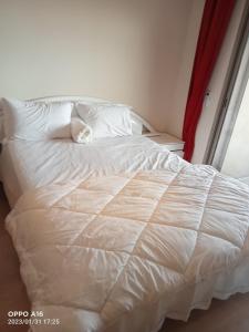a white bed with a cat laying on top of it at Appartement Prestigia Marrakech in Marrakech