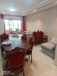 a living room with a table and chairs and a couch at Appartement Prestigia Marrakech in Marrakech