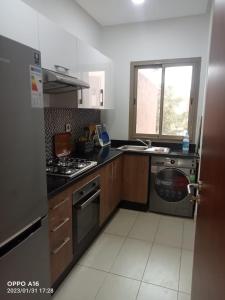 Il comprend une cuisine équipée d'une cuisinière et d'un lave-linge. dans l'établissement Appartement Prestigia Marrakech, à Marrakech