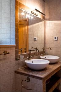 La salle de bains est pourvue de 2 lavabos blancs et d'un miroir. dans l'établissement La Dorada Holiday Home, à Trsteno