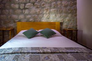 a bedroom with a bed with two green pillows at La Dorada Holiday Home in Trsteno