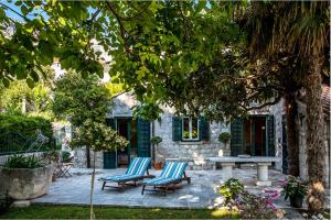 une terrasse avec deux chaises et une table en face d'une maison dans l'établissement La Dorada Holiday Home, à Trsteno