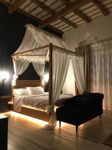 a bedroom with a canopy bed and a couch at Villa White Luxury Residence in Marsala