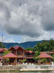 a large building with red roofs on the water at Gokhon Guest House in Tuk Tuk