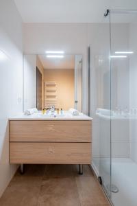La salle de bains est pourvue d'un lavabo et d'une douche. dans l'établissement Veeve - Blue Daisy Brilliance, à Levallois-Perret