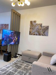 sala de estar con sofá y TV de pantalla plana en Maxine Staycation, en Manila