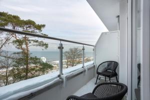 een balkon met 2 stoelen en uitzicht op het strand bij Hotel Seebrücke in Lubmin