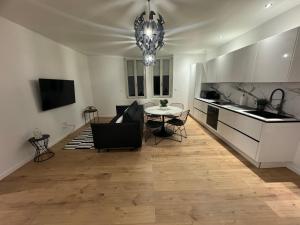 a living room with a table and a kitchen at Appartement VIII - Haut Standing proche Luxembourg et Cattenom in Nilvange
