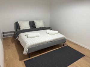 1 cama con 2 almohadas en una habitación en Appartement VIII - Haut Standing proche Luxembourg et Cattenom, en Nilvange
