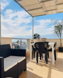 una sala da pranzo con tavolo, sedie e vista sull'oceano di ALÌKA apartment a Agrigento