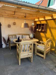 d'une terrasse avec une table, deux chaises et un banc. dans l'établissement "Ohuus" Ferienwohnung mit eingezäuntem Garten, à Büsum