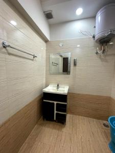uma casa de banho com um lavatório e um espelho em MALAYA HOUSE --Couples, Family, Corporate Favorite-- Near BMC Chowk ICONIC Mall em Jalandhar