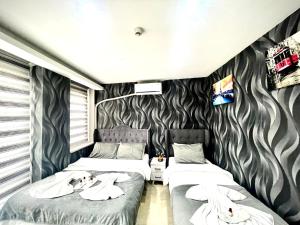 2 Betten in einem Zimmer mit schwarzweißer Tapete in der Unterkunft Taksim Central House Hotel in Istanbul