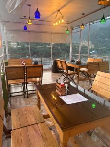 ein Restaurant mit Tischen und Stühlen und Aussicht in der Unterkunft The Peninsulla in Rishikesh