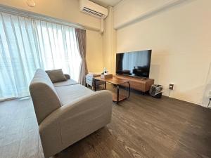 a living room with a couch and a flat screen tv at NIYS apartments 37 type in Tokyo