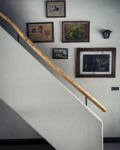 a staircase with pictures on the wall and a stair rail at Statek Blatiny in Sněžné