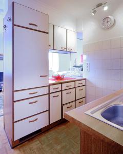 a kitchen with a white refrigerator and a sink at Komfort Appartement Sylt - direkt am Strand - in Westerland (Sylt)