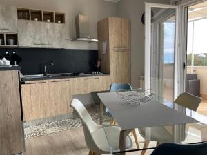 cocina y comedor con mesa y sillas en ALÌKA apartment en Agrigento