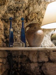 a shelf with bottles and a vase on it at La Torre del Visco - Relais & Châteaux in Fuentespalda