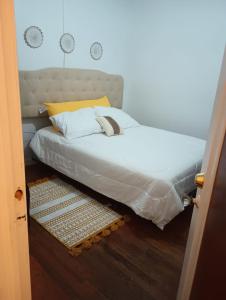 a bed with a white comforter on top of it at Cozy- Chic room in a very quiet area in Detroit