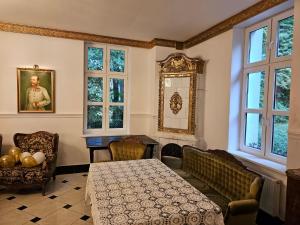 Cette chambre comprend une table, des chaises et des fenêtres. dans l'établissement Kasztanowy Dwór, à Cieszyn
