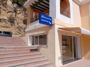 a building with stairs and a sign that reads mexican hospital at Apartamentos HC Burriana Playa in Nerja