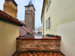 a view of an alley between two buildings with a clock tower at Apartmány Rangifer in Plzeň