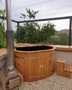 bañera de hidromasaje en una terraza junto a una ventana en Strawbale Cottage - Wingspread Garden, en Strath Creek