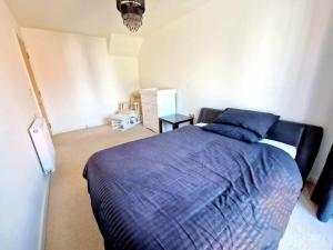 a bedroom with a large bed with a blue comforter at Explore London: 2 Bedroom House in Wood Green in London