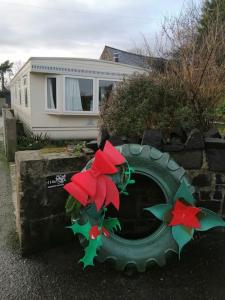 a fake flower on a tire in front of a house at Midden Manor: Farm stay in rural County Antrim. in Cullybackey
