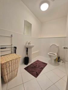 a white bathroom with a toilet and a sink at Explore London: 2 Bedroom House in Wood Green in London