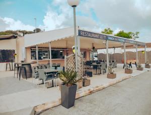 a restaurant with tables and chairs in front of a building at Camping Europcamping in Fréjus