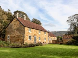 um velho edifício de tijolos com uma mesa de piquenique num campo em Cliff Cottage em Thirsk