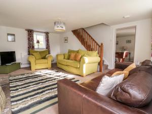 a living room with a couch and two chairs at Cliff Cottage in Thirsk
