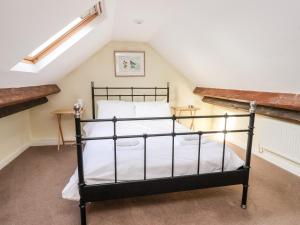 um quarto com uma cama preta num sótão em Cliff Cottage em Thirsk